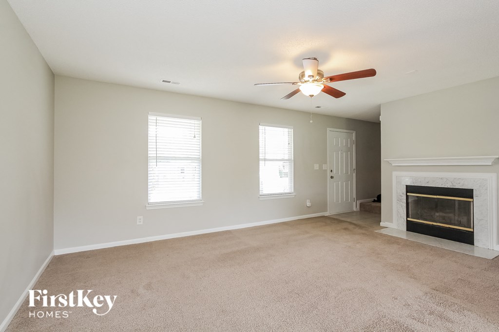 a living room with a fireplace and a ceiling fan
