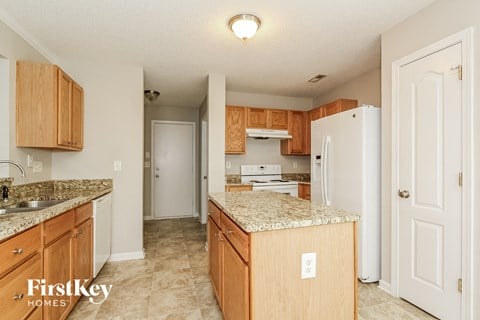 a kitchen with wood cabinets and granite counter tops and a white refrigerator
