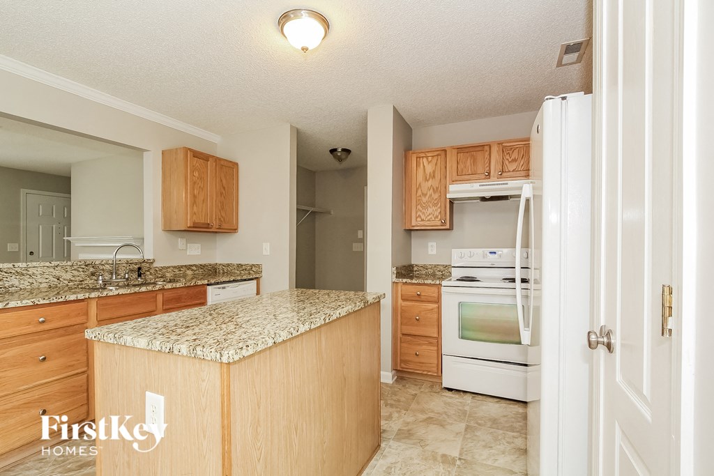 a kitchen with white appliances and granite counter tops