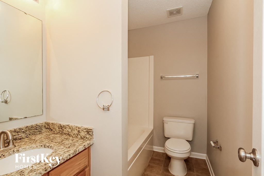 a bathroom with a toilet and a sink and a mirror