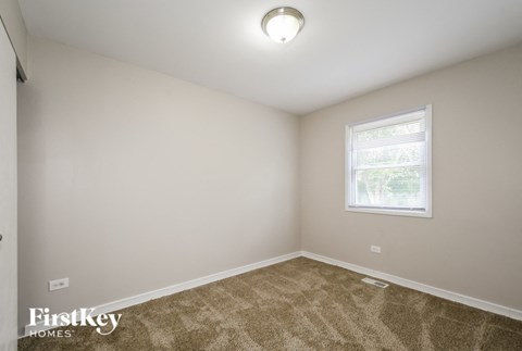 the living room of a home with carpet and a window