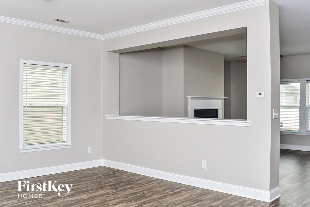 the living room of a new home with a window and a fireplace