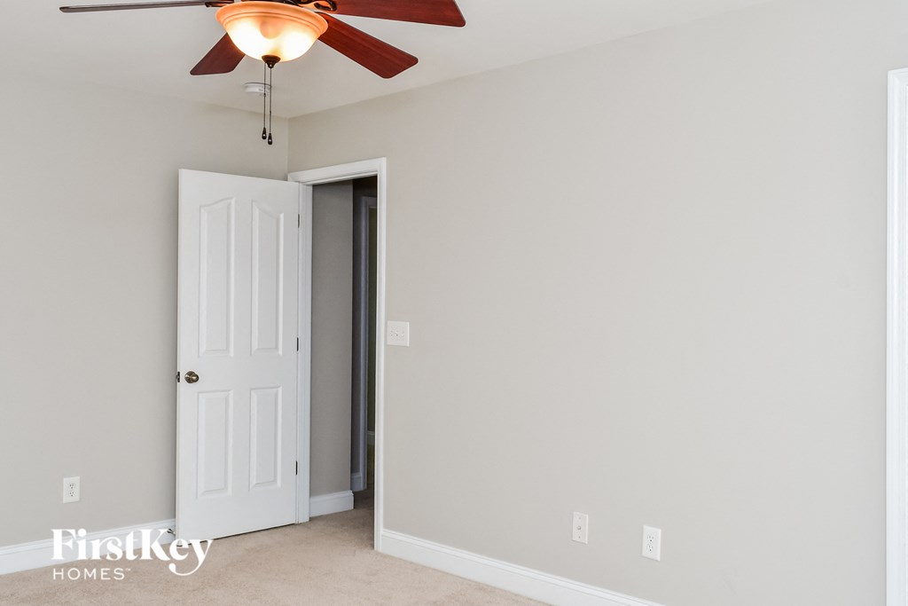 a bedroom with a ceiling fan and a closet