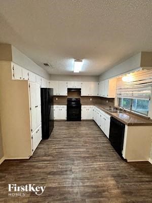 A kitchen with wooden floors and white cabinets.