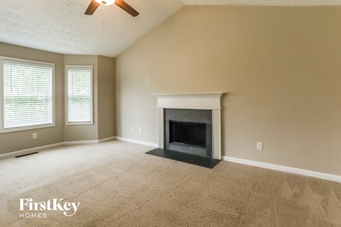 A room with a fireplace and a ceiling fan.