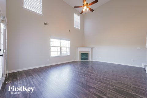A spacious room with a fireplace and a ceiling fan.