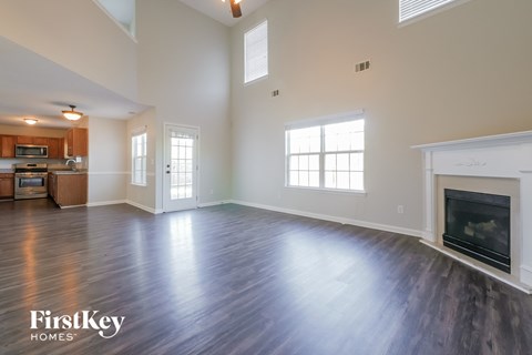 A spacious living room with wood flooring and a fireplace.