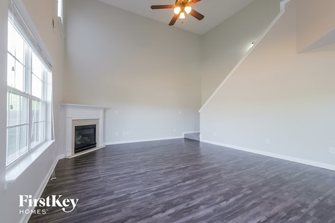 A spacious room with a fireplace and wood flooring.