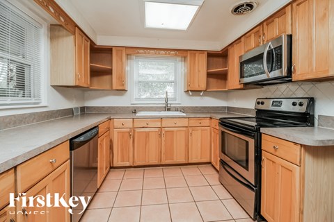 A kitchen with wooden cabinets and a black stove top oven.