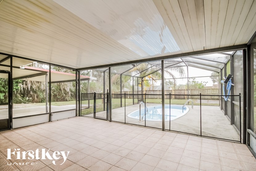 A sunroom with a pool and a FirstKey Home logo.