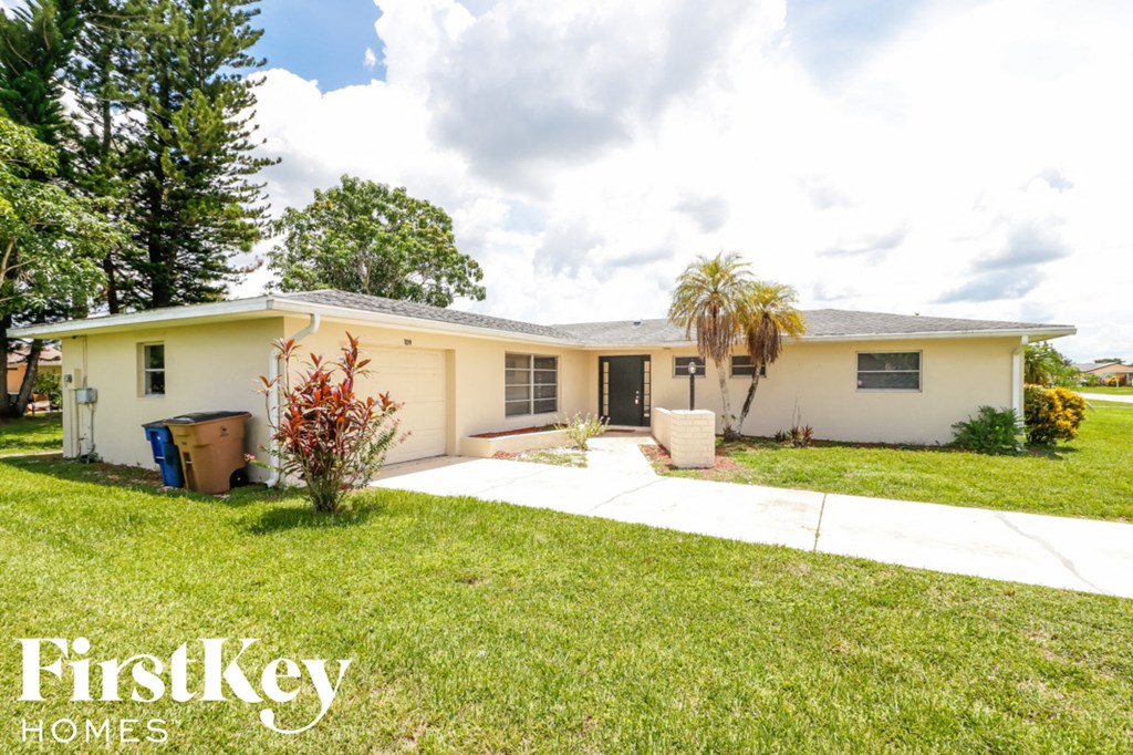 A house with a white front yard and a palm tree.