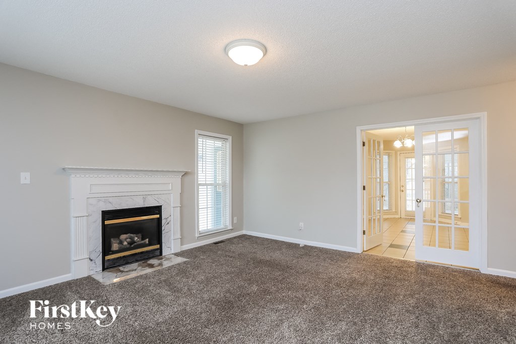 A room with a fireplace and a carpeted floor.