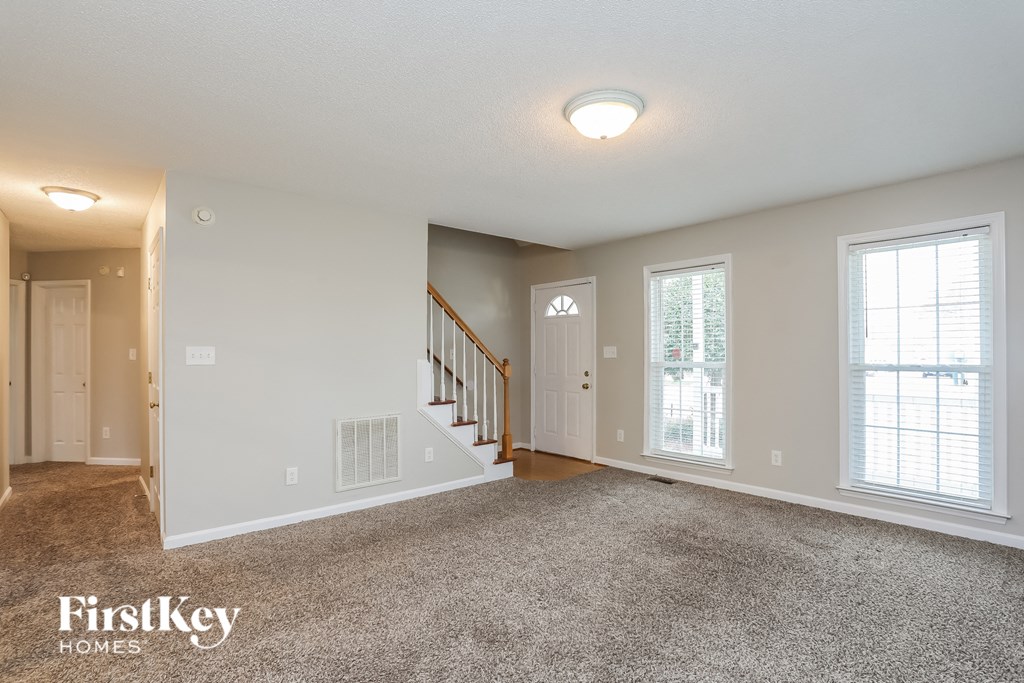 A spacious room with a staircase and a window.