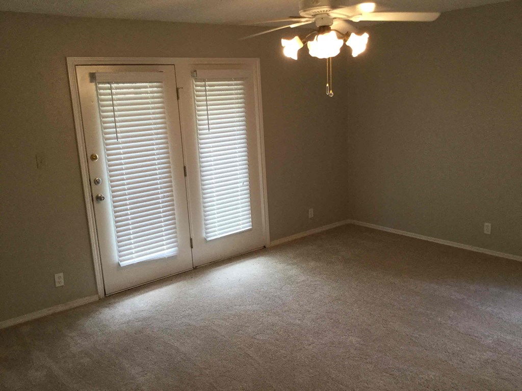 a empty room with a ceiling fan and doors