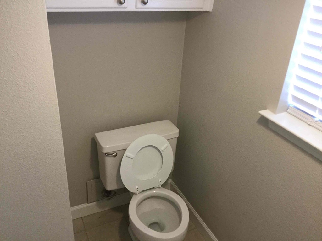 a small bathroom with a toilet and a window
