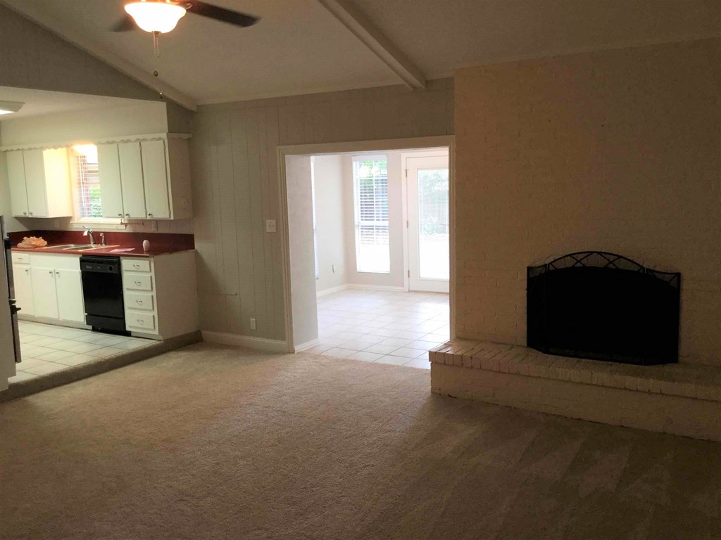 an empty kitchen and living room with a fireplace