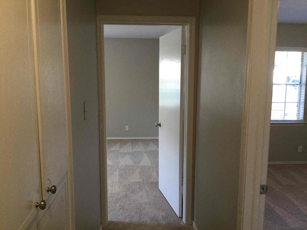 a view of the master bedroom from the hallway with the closet door open