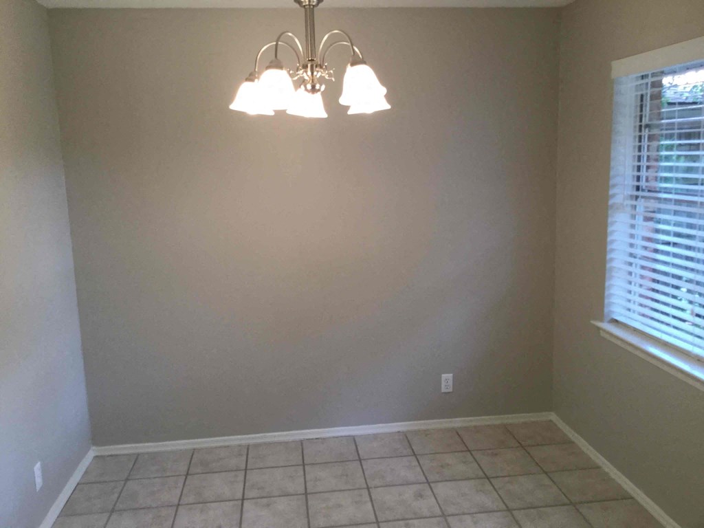 a dining room with a light fixture and a tiled floor