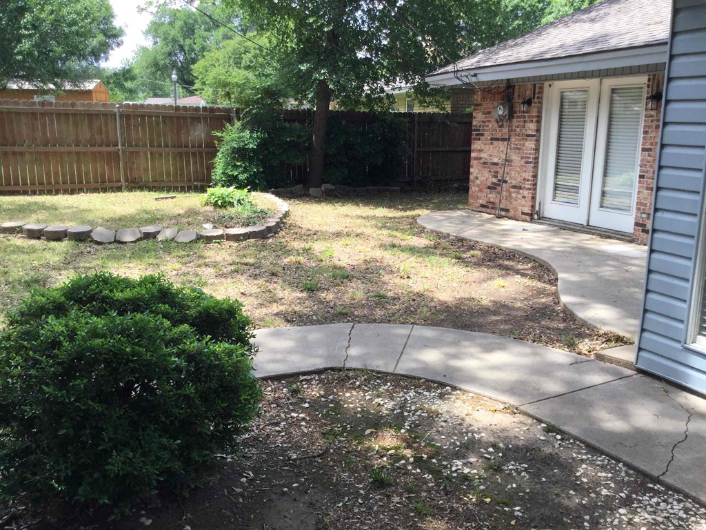 a side yard with a sidewalk and a house