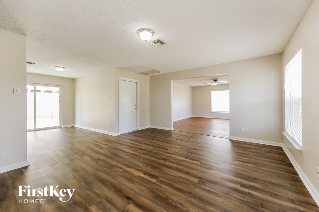 the living room and dining room with hardwood flooring and white walls