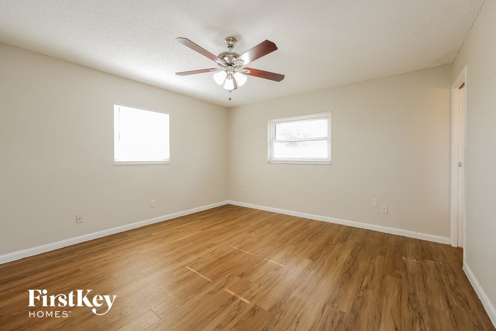 a living room with hardwood floors and a ceiling fan