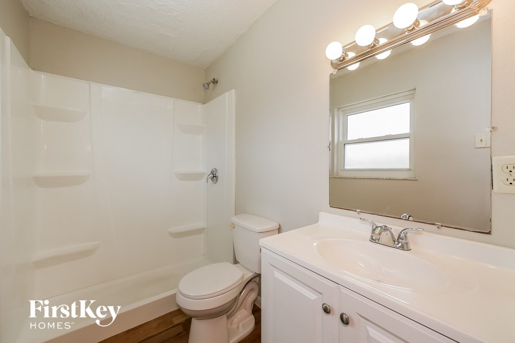 a bathroom with a sink toilet and a mirror