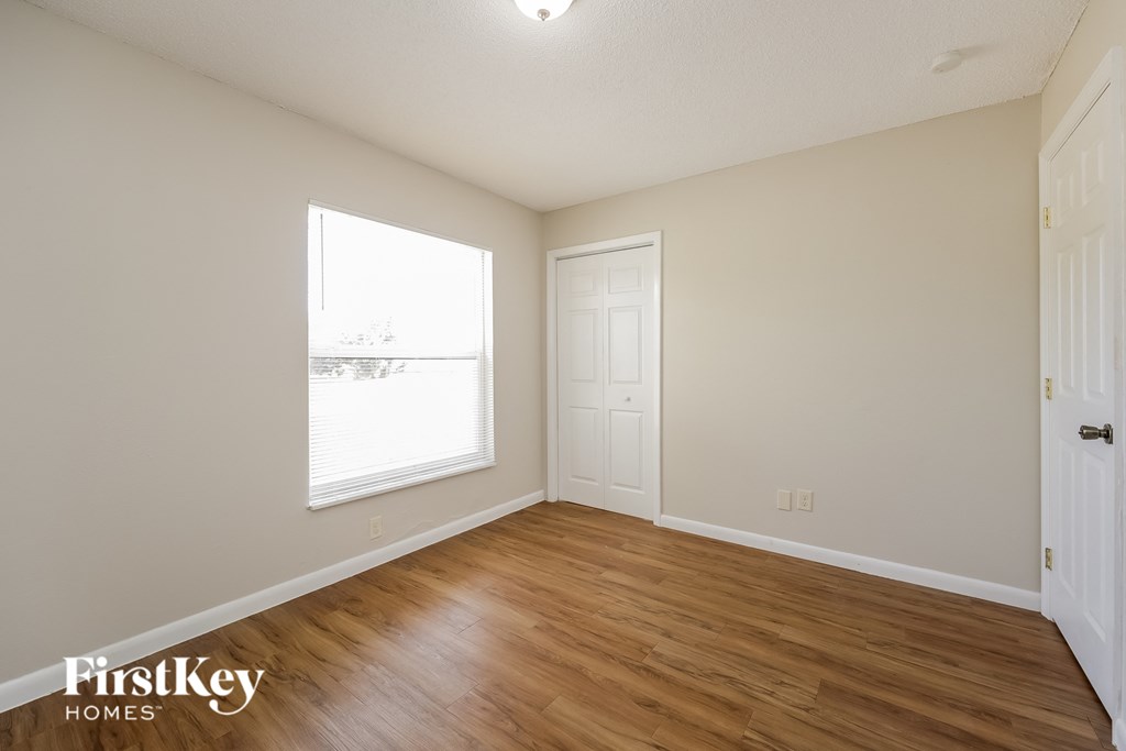 the living room of an apartment with wood flooring and a window