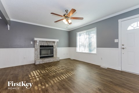 a living room with a fireplace and a ceiling fan