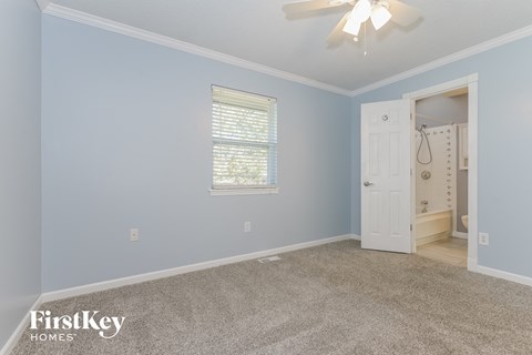 a bedroom with blue walls and a white door to a bathroom