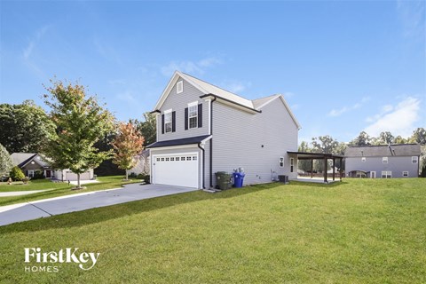 a white house with a white garage door and a lawn
