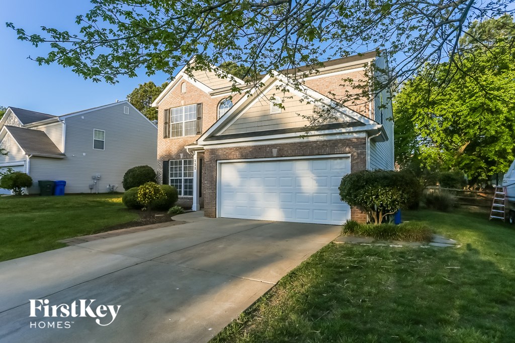 a house with a white garage door in front of a lawn