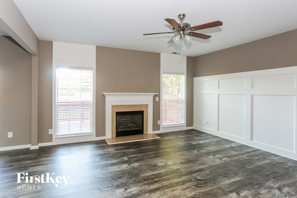 a living room with a fireplace and a ceiling fan