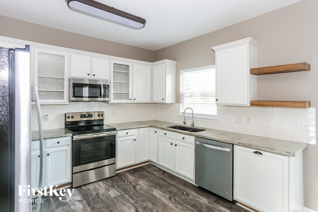 a kitchen with white cabinets and stainless steel appliances