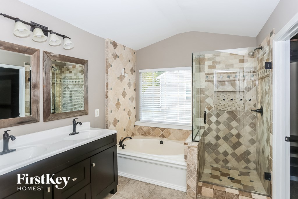 a bathroom with a tub and a shower and a sink