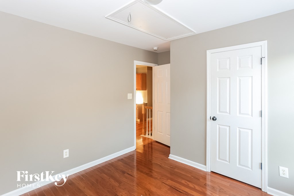 a bedroom with wood floors and a white door