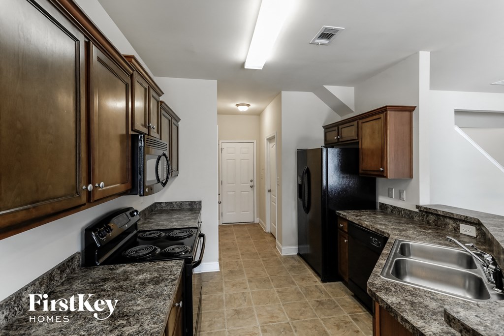 a kitchen with black appliances and granite counter tops