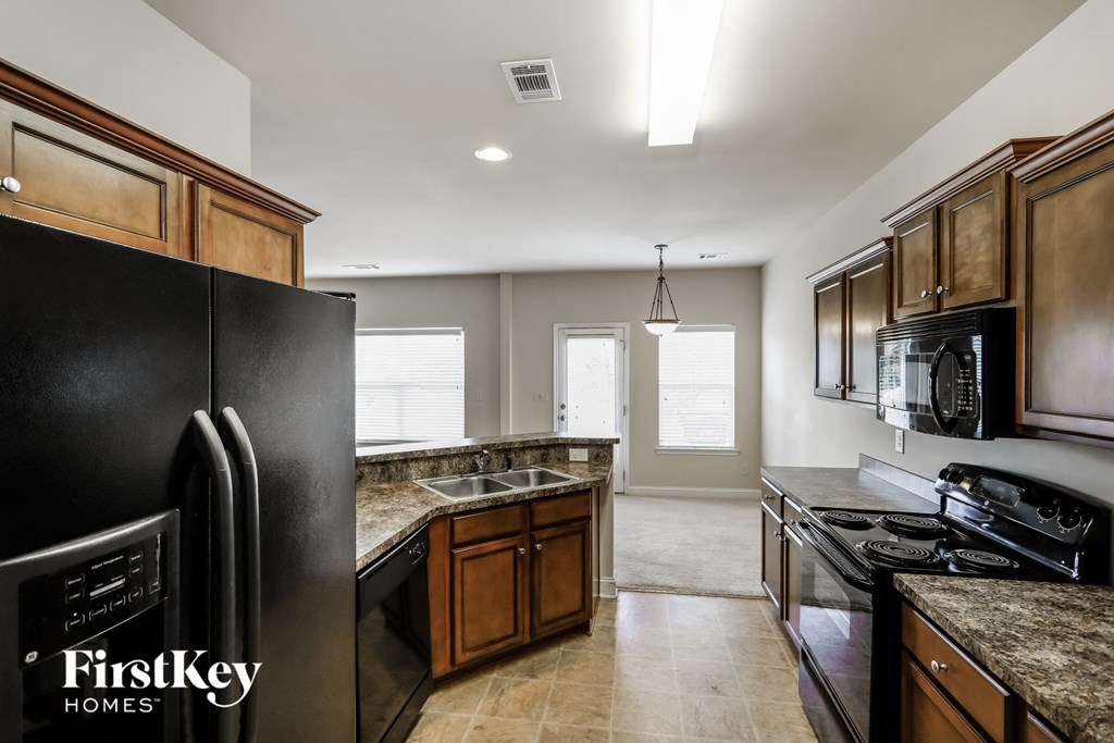 a kitchen with black appliances and brown cabinets