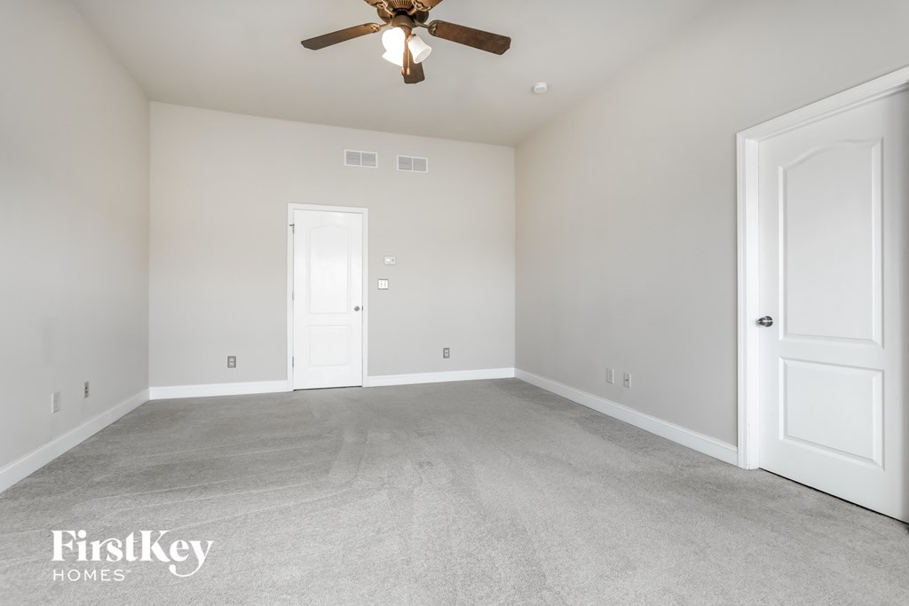 a bedroom with a carpeted floor and a ceiling fan
