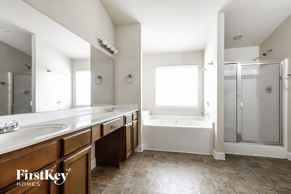 a bathroom with two sinks and a tub and a shower