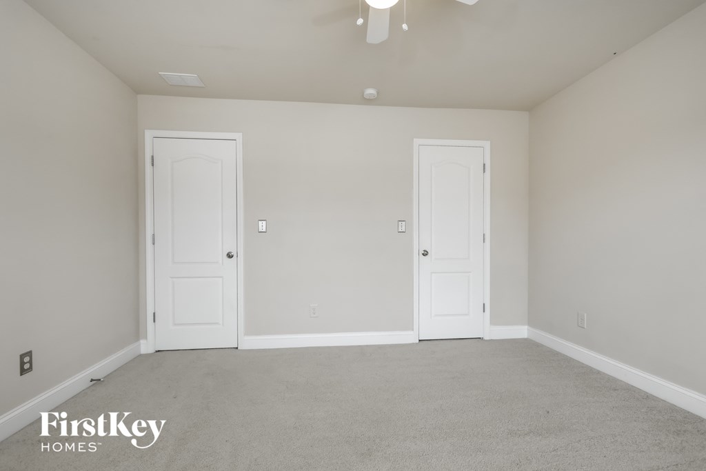 a bedroom with two doors and a carpeted floor