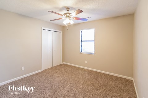 a bedroom with carpet and a ceiling fan