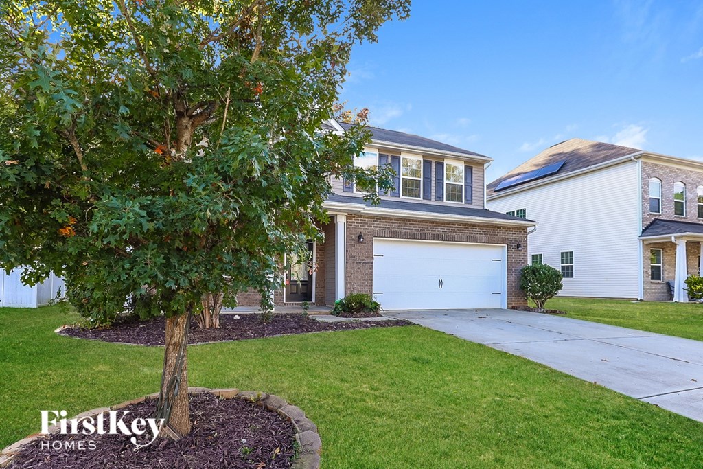 A tree in front of a house with the words "FirstKey Homes" on the bottom left.