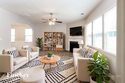 A living room with a white couch, a coffee table, and a ceiling fan.