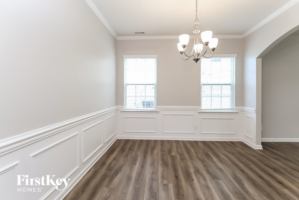A room with wooden floors and a chandelier.