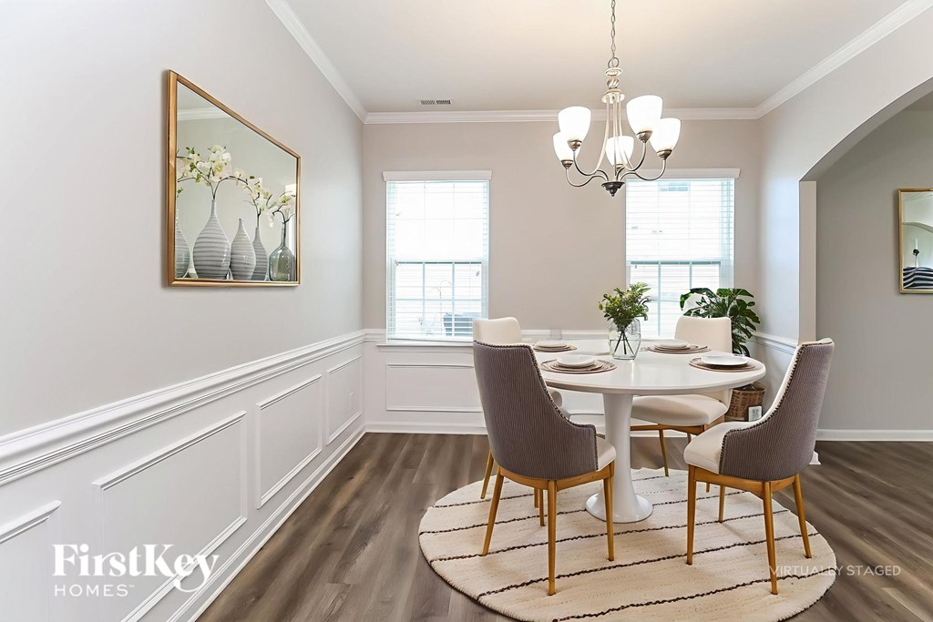 A dining room with a white table and chairs.