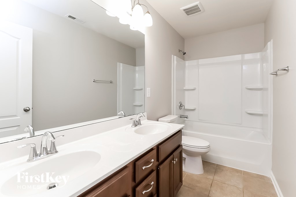 A white bathroom with a toilet, sink, and bathtub.