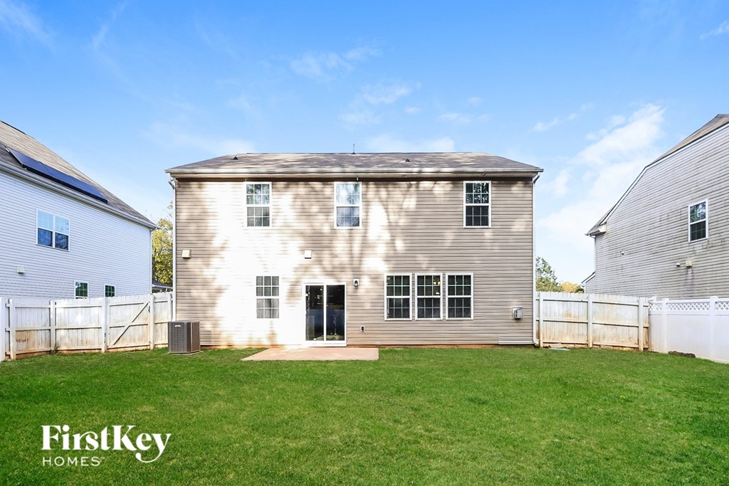 A large house with a fence and a grassy yard.
