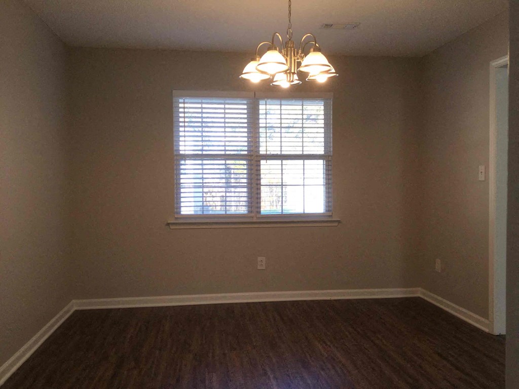 A room with a window and a chandelier.
