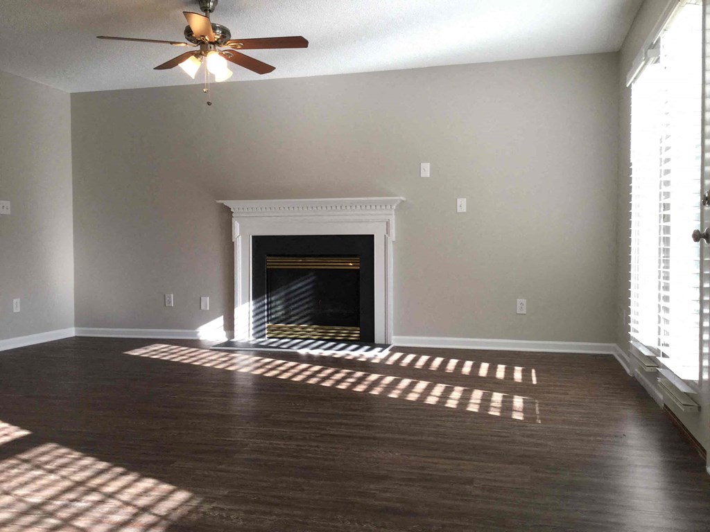 A room with a fireplace and a ceiling fan.