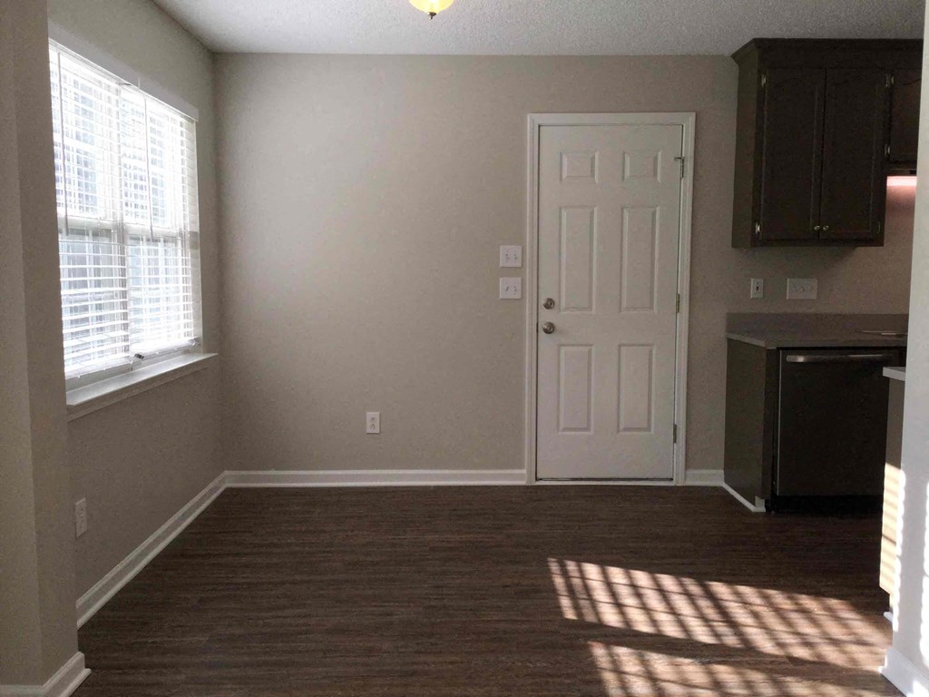 A room with a white door and a window with blinds.